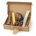Box cadeau pour chien Capitaine Croq, taille petit chien, boîte kraft ouverte avec ruban et étiquette : patte de cerf, Croq'Fromage, corne de buffle, cubes de récompense et peau de saumon